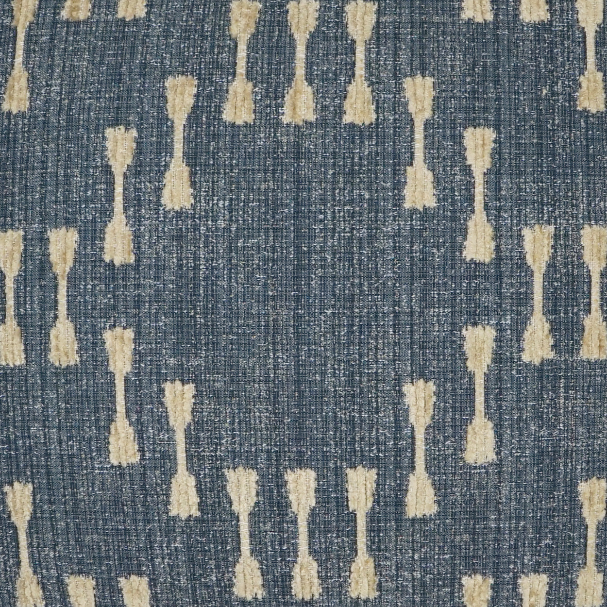 Blue textured fabric with cream tassel-like shapes in vertical, repeating pattern; boho-inspired textile.