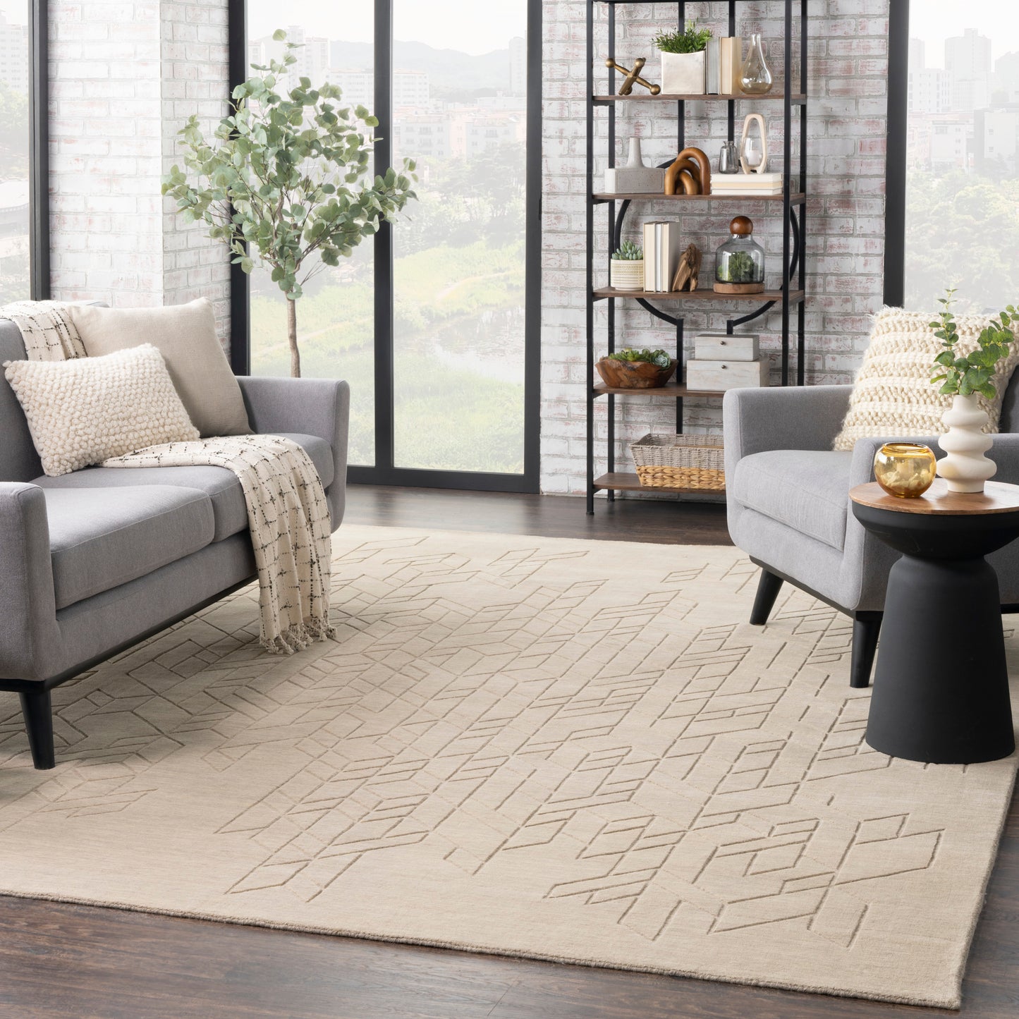 Beige geometric area rug in a modern living room with gray sofas, large windows, black metal shelf and plants.