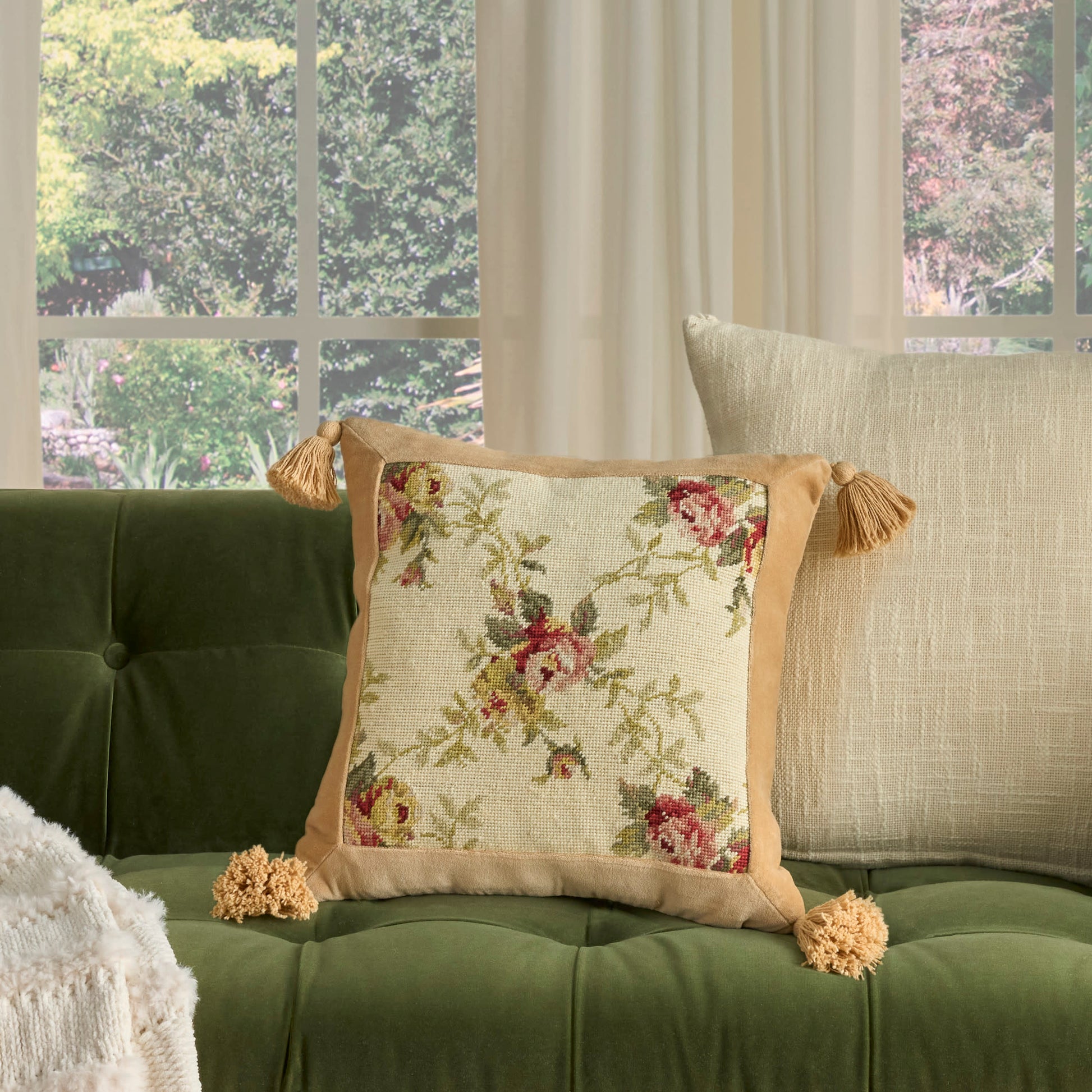 Cream 19 x 19 decorative pillow with a square floral-embroidered center, beige border and tassels.