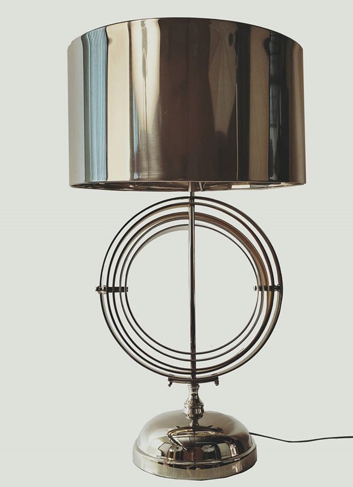 Polished chrome table lamp with a large metallic drum shade and stacked circular rings, mid-century modern style.