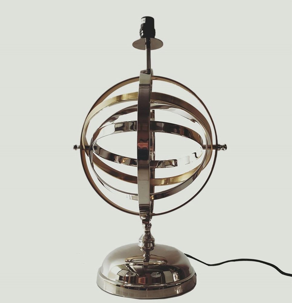 Chrome globe lamp with concentric circular rings around a vertical axis on a round base; corded.
