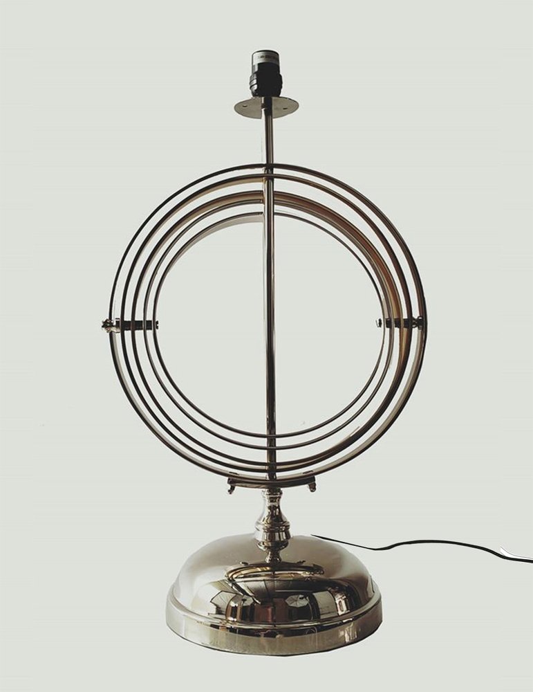 Brass-finished table lamp with nested concentric circular rings around a vertical stem, rounded base and visible cord.