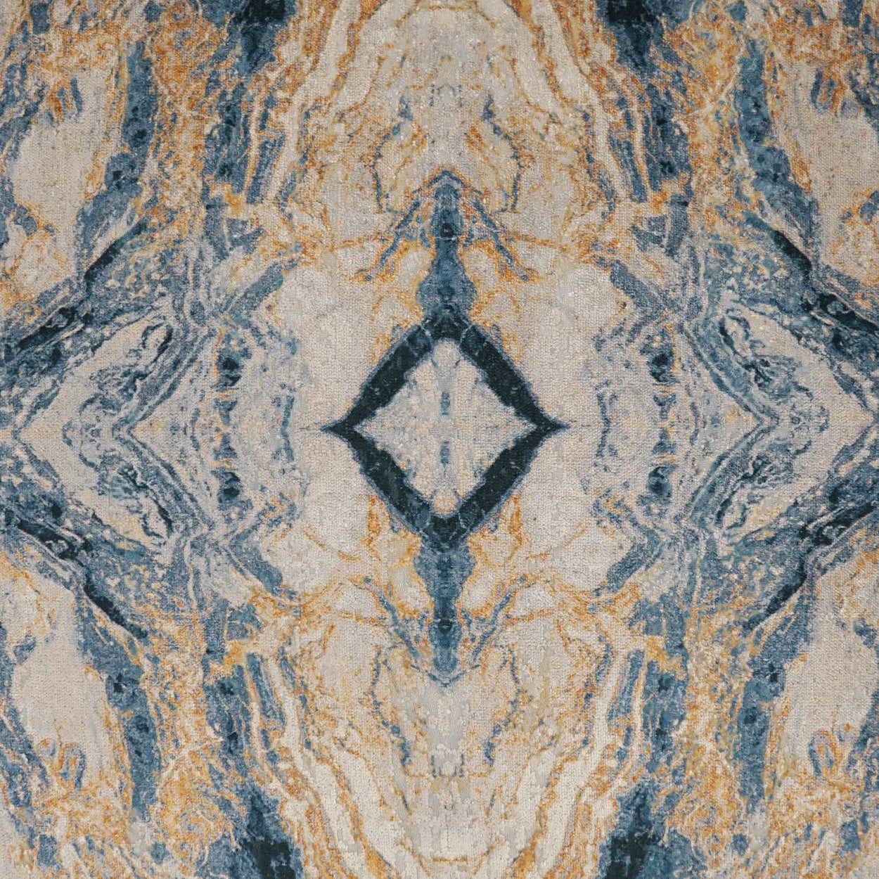 Kaleidoscopic blue, beige and gold marbled fabric with a central diamond motif; decorative textile