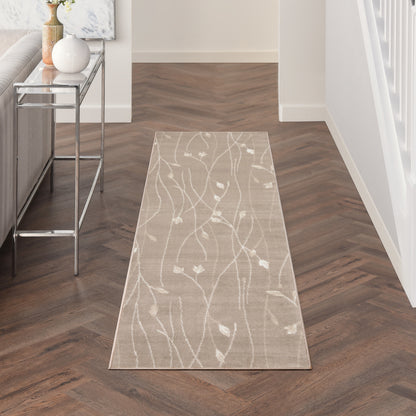 Beige runner rug with white botanical vine pattern on dark herringbone wood floor in entryway.