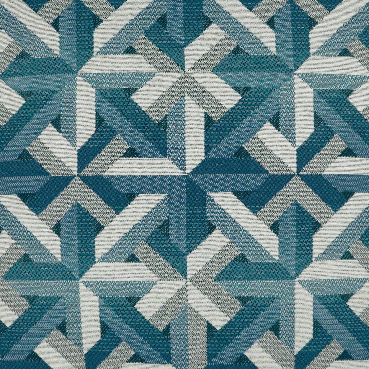 Woven geometric fabric with interlocking blue chevrons and star motifs; teal, navy, light blue, gray.