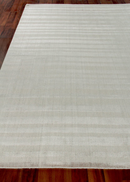 Cream ivory rectangular rug with subtle horizontal stripes and hand-loomed texture on a dark wooden floor.