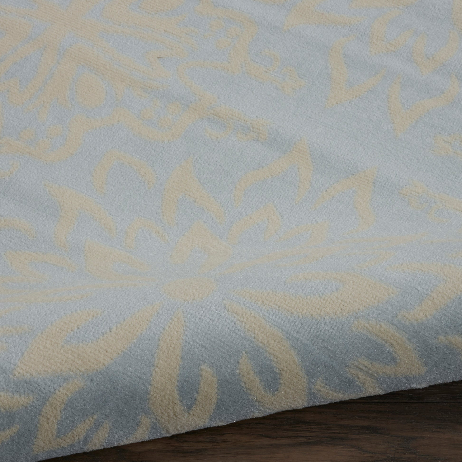 Rectangular light-blue rug with beige floral damask pattern in soft woven fabric, 8' x 10'.