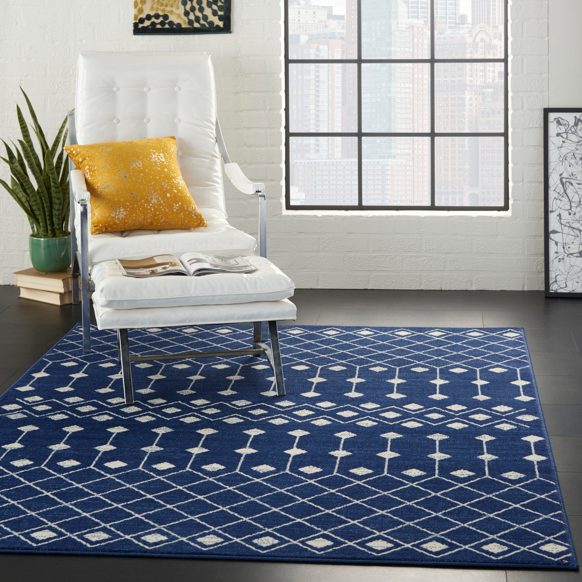Navy blue geometric area rug with white diamond pattern under a white tufted lounge chair and mustard pillow.