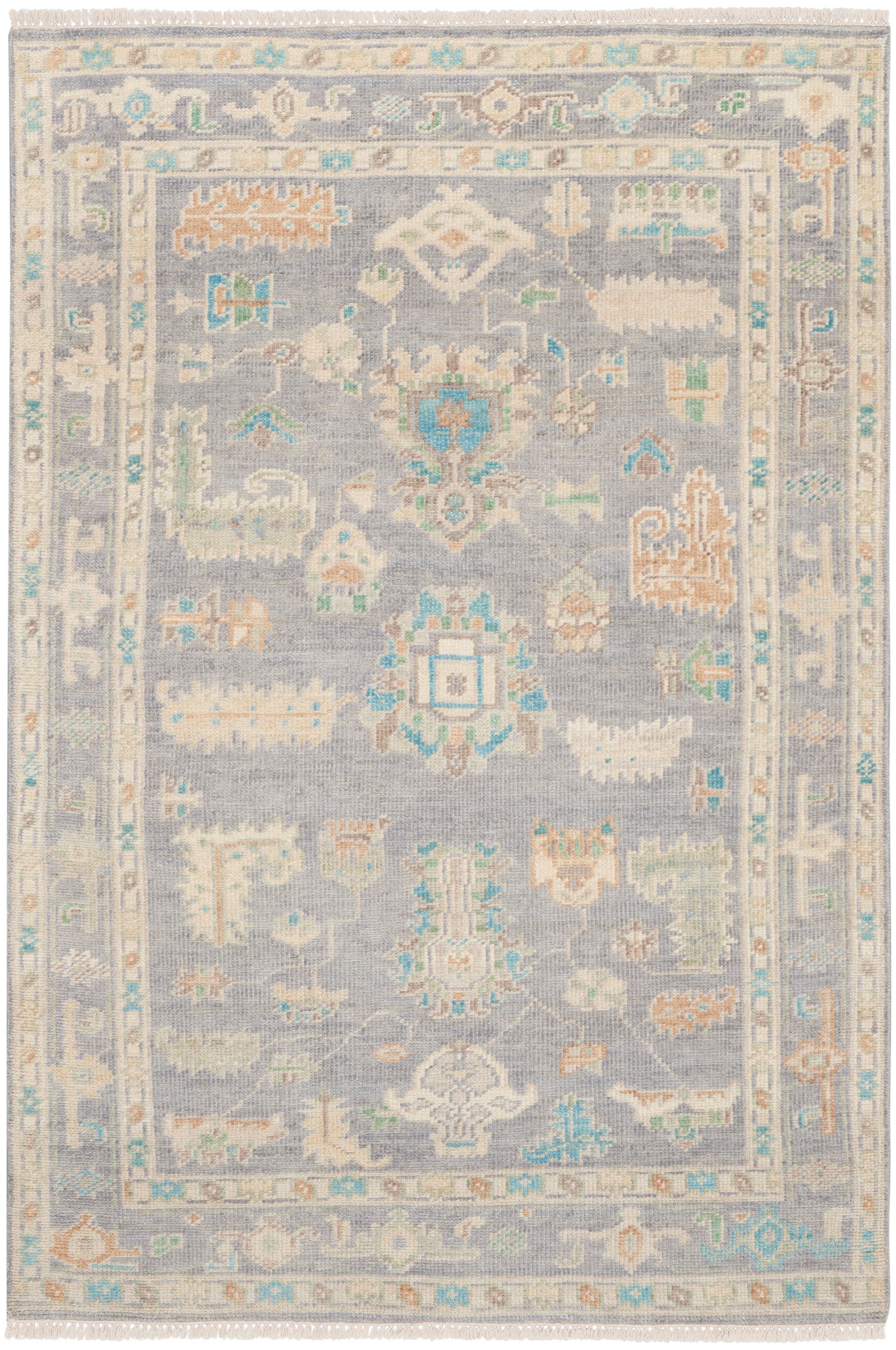 Rectangular oriental rug, 6' x 8', with a light blue-gray field, ivory, peach and turquoise motifs, and intricate borders with fringed edges.