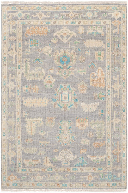 Rectangular oriental rug, 6' x 8', with a light blue-gray field, ivory, peach and turquoise motifs, and intricate borders with fringed edges.