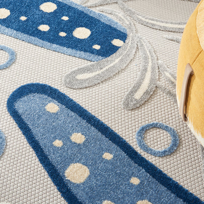 Abstract blue round rug with navy and light blue oval shapes, cream dots and gray lines on a beige background; suitable for children's room decor.