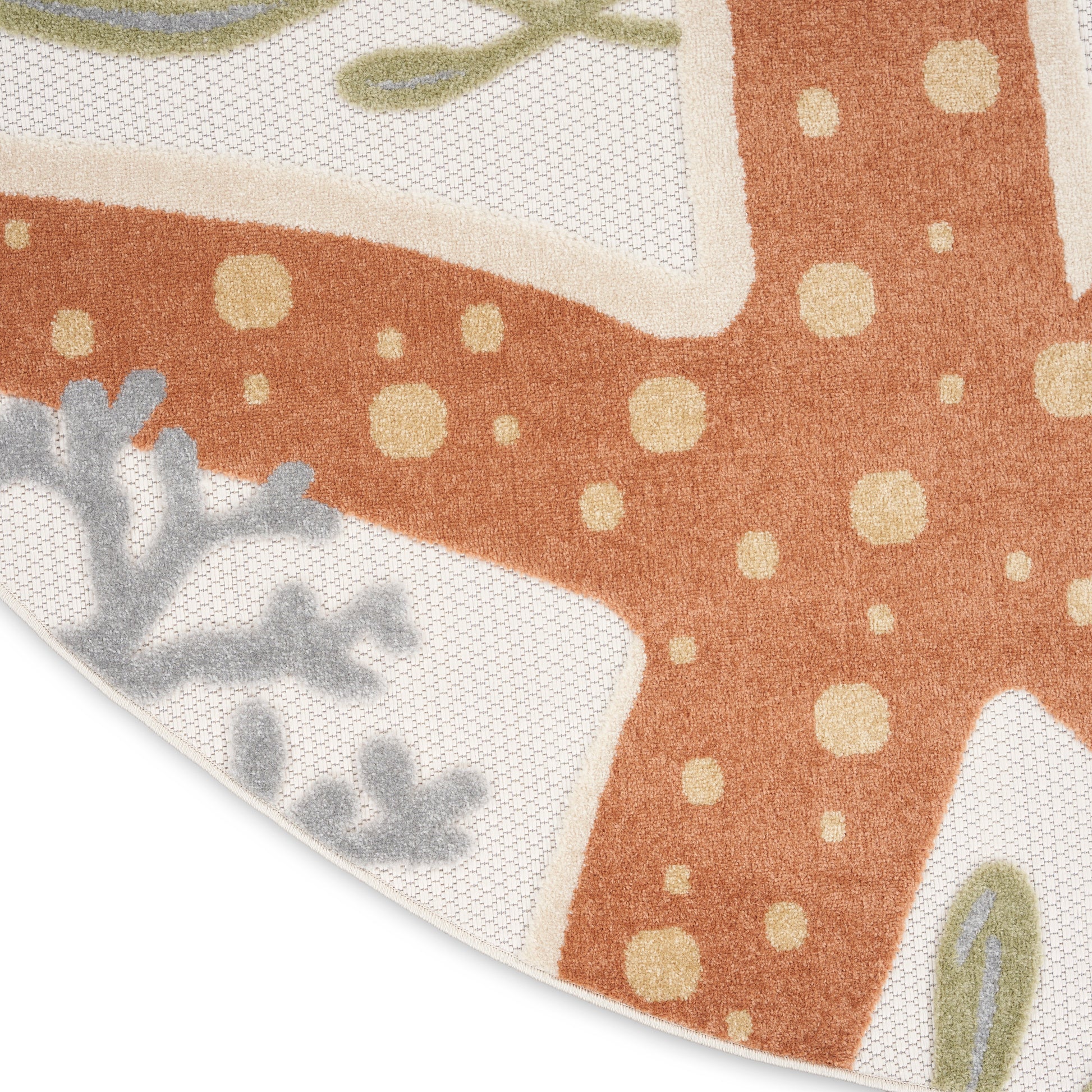 Partial view of an orange patterned rug with cream polka dots, curved white border sections, and gray-green leaf motifs.