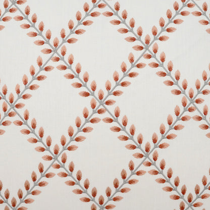 Cream pillow fabric with gray diagonal stems and orange leaf clusters forming a diamond lattice pattern.
