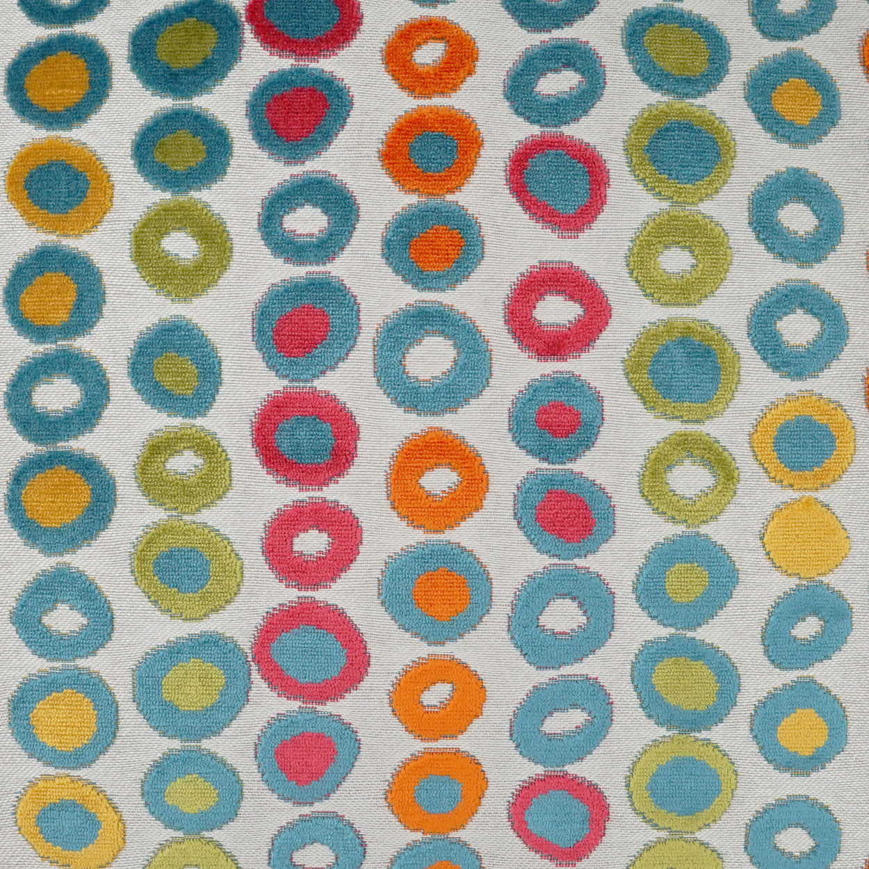Colorful donut-like ring pattern on fabric with blue, teal, yellow, orange, pink and lime circles on white.