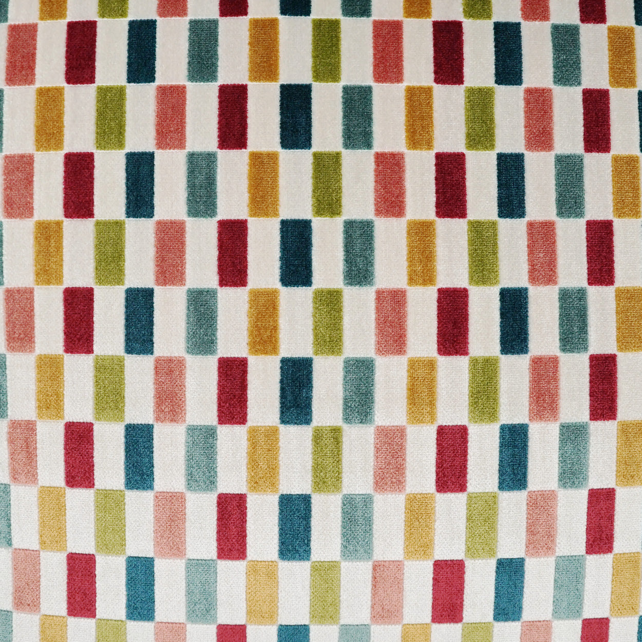 Colorful woven fabric with a grid of vertical color blocks in red, pink, mustard, teal & navy.