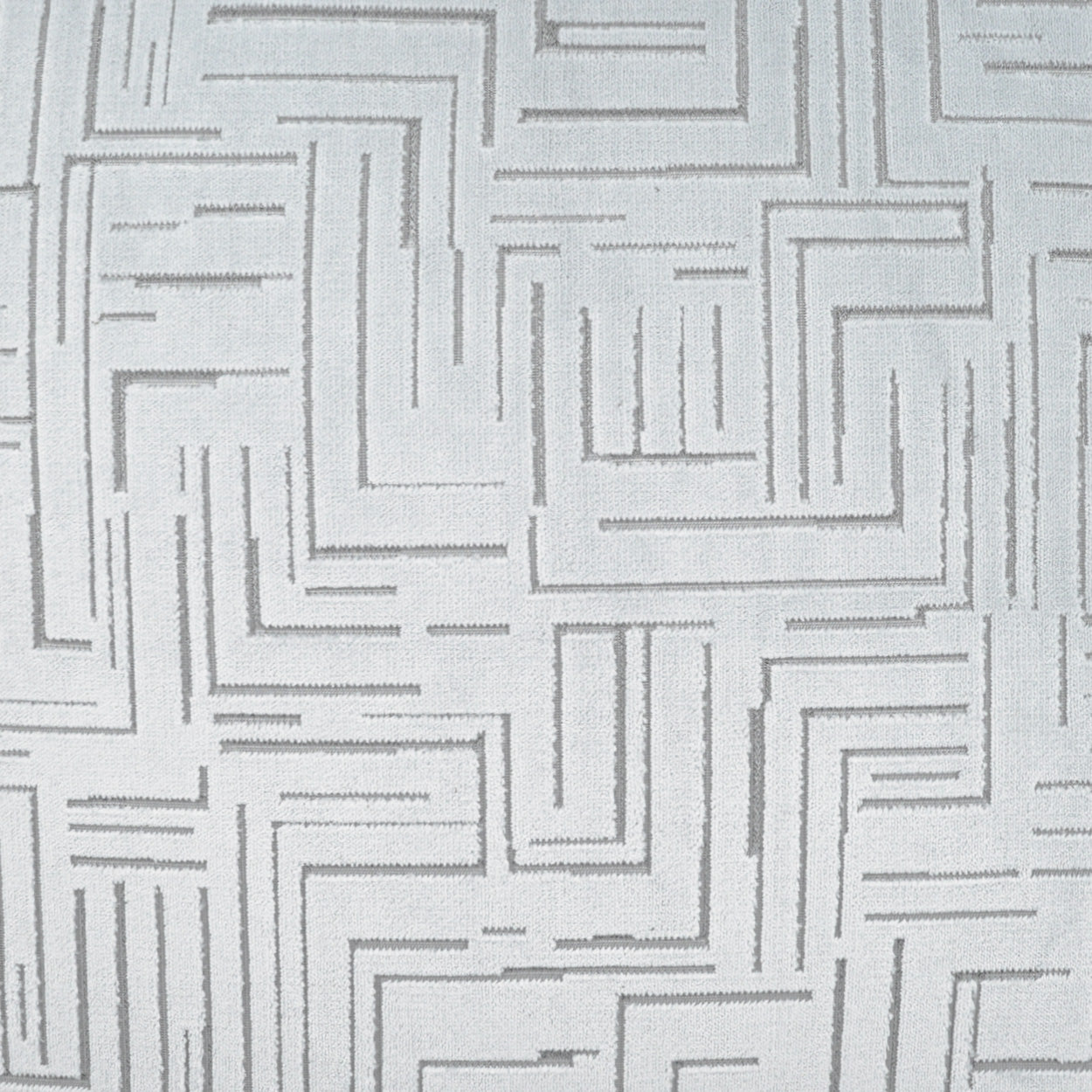 Light gray fabric with a geometric maze pattern of stitched lines, modern upholstery textile.