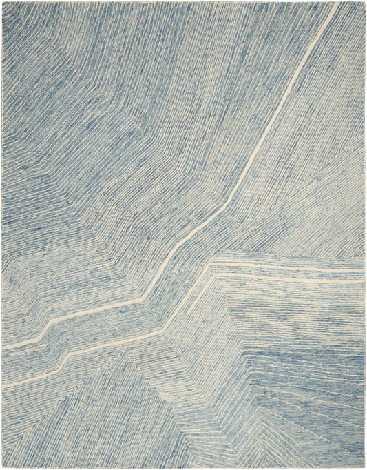 Blue and white abstract chevron rug with layered zigzag lines and textured weave.
