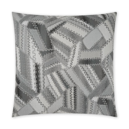 Square decorative pillow in charcoal-grey patchwork quilt design with zigzag stitched edges; modern monochrome throw pillow.