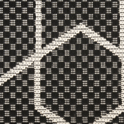 Close-up of black & white woven fabric with checkerboard/diamond pattern, textured textile for fashion accessories.