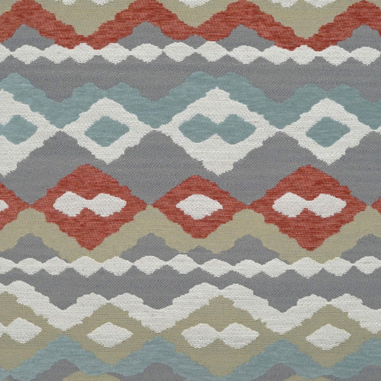 Ikat-inspired geometric fabric with stacked diamond motifs in rust, olive, teal, taupe and ivory; boho textile.