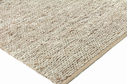 Natural beige braided jute rug with chunky woven plaits and a tan border.