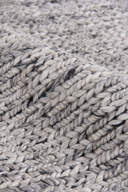 Close-up of chunky grey hand-woven rug texture with thick wool pile; textured ribbed weave, 5' x 8' indoor rug.