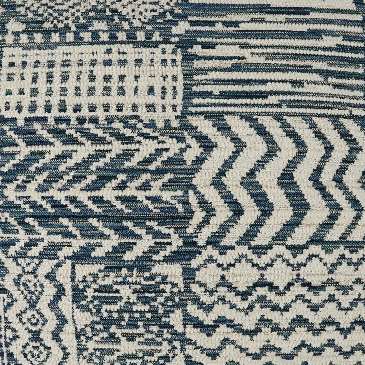 Navy and ivory woven fabric with geometric chevrons and blocks, rustic tribal pattern for upholstery or decor.
