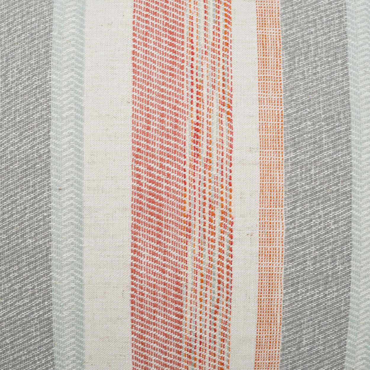 Woven striped pillow featuring gray, cream, red plaid and orange accent stripes.
