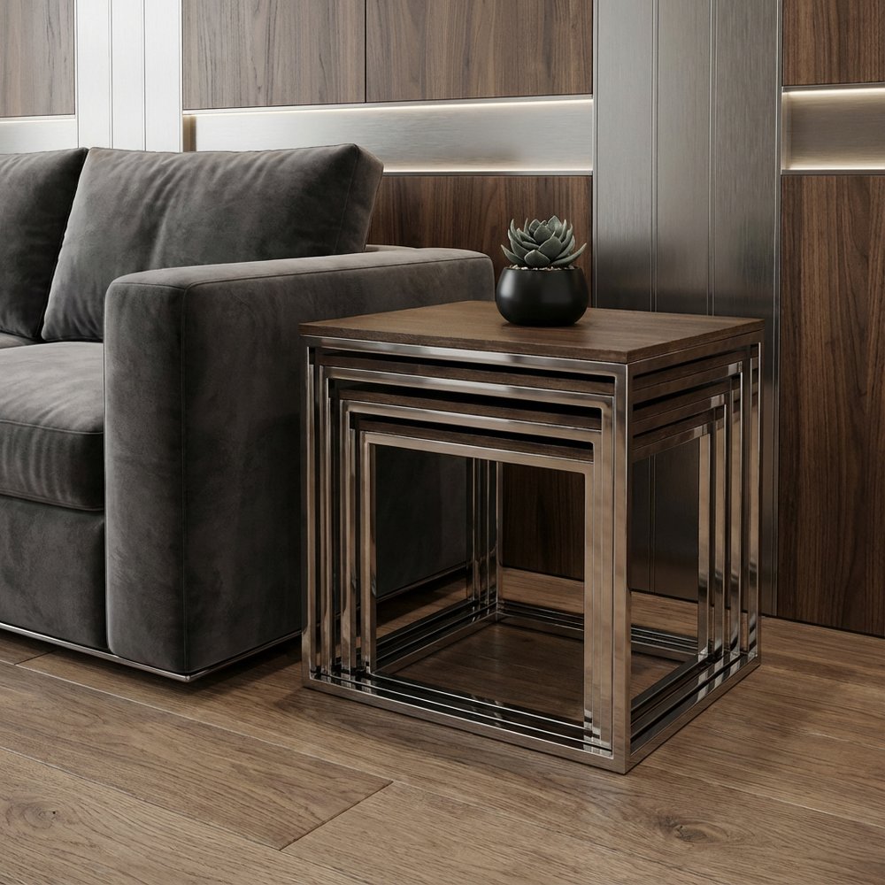 Bronze metal nested side tables with wood top and geometric frame beside a dark grey sofa, a black succulent planter on top.