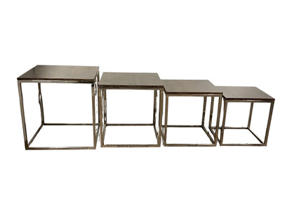 Four-piece set of industrial nesting tables with square metal frames and flat brushed steel tops.