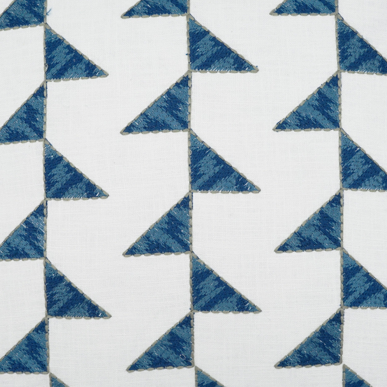 White fabric with blue textured triangles in a vertical zigzag chevron pattern.