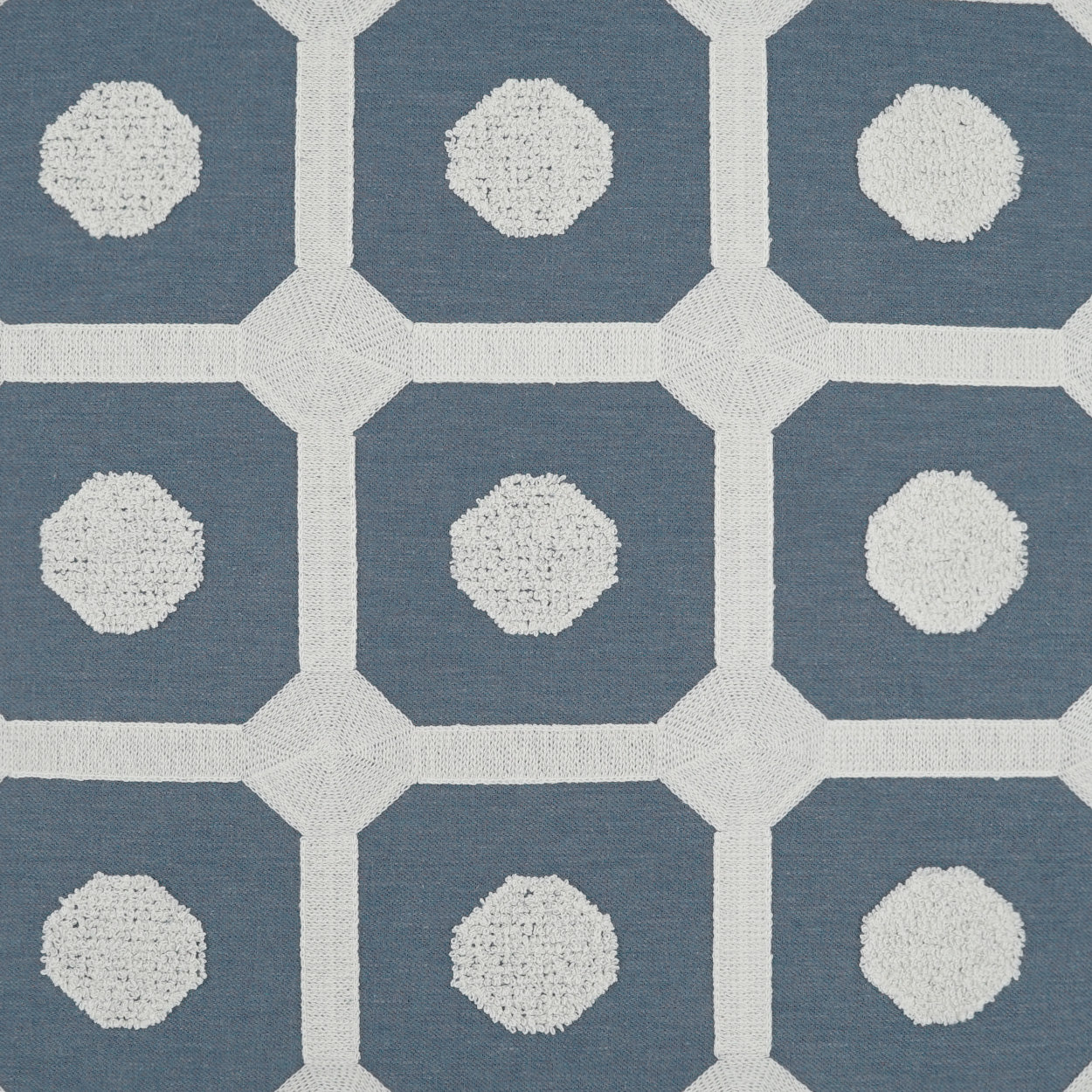 Blue fabric with a white lattice grid and pale textured circles in each cell; modern geometric pattern.