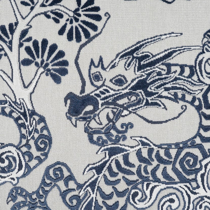 Blue dragon motif woven on white fabric; decorative pillow with Asian dragon design and swirling pattern.