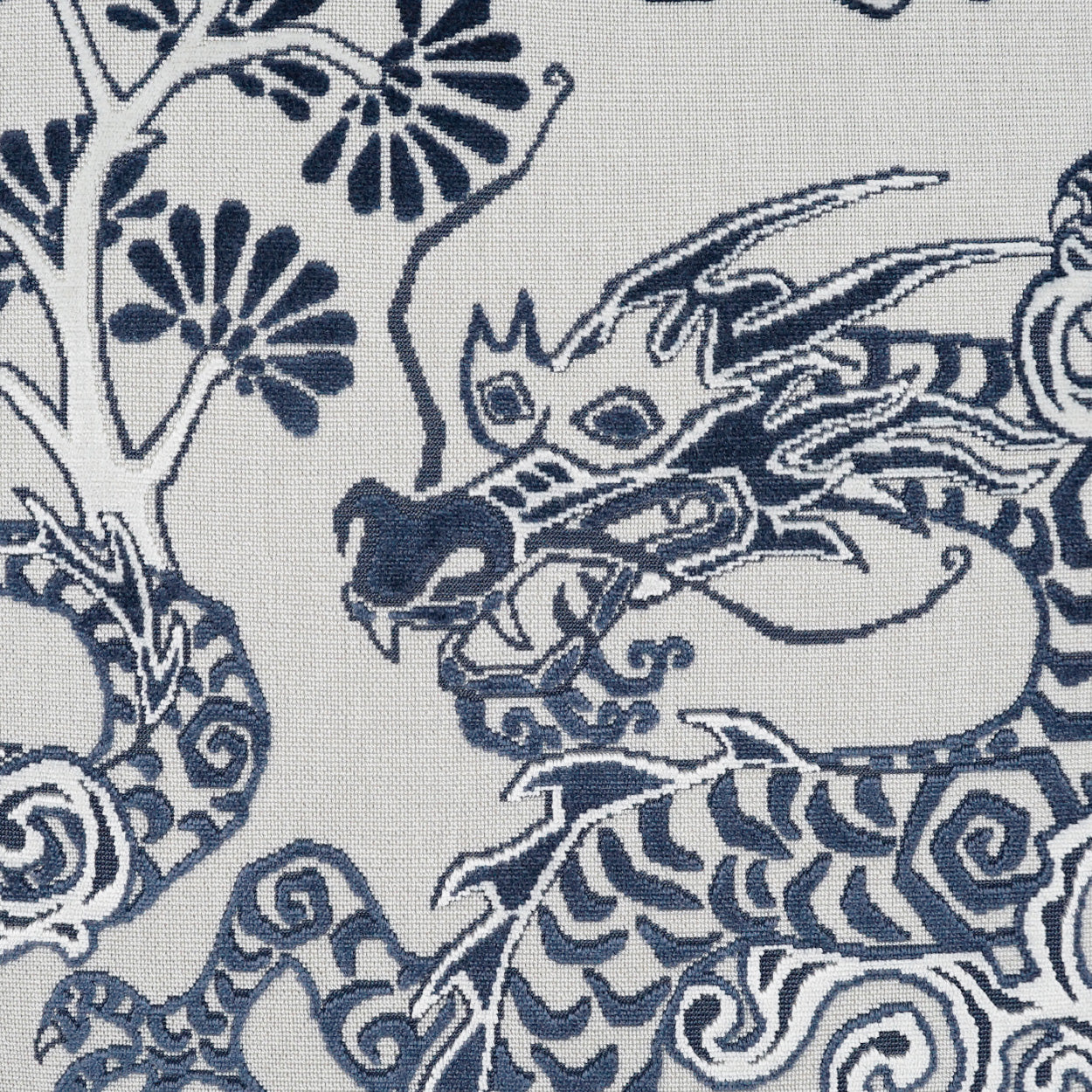 Blue dragon motif on light fabric; navy line-art with swirls and florals in a traditional textile pattern.