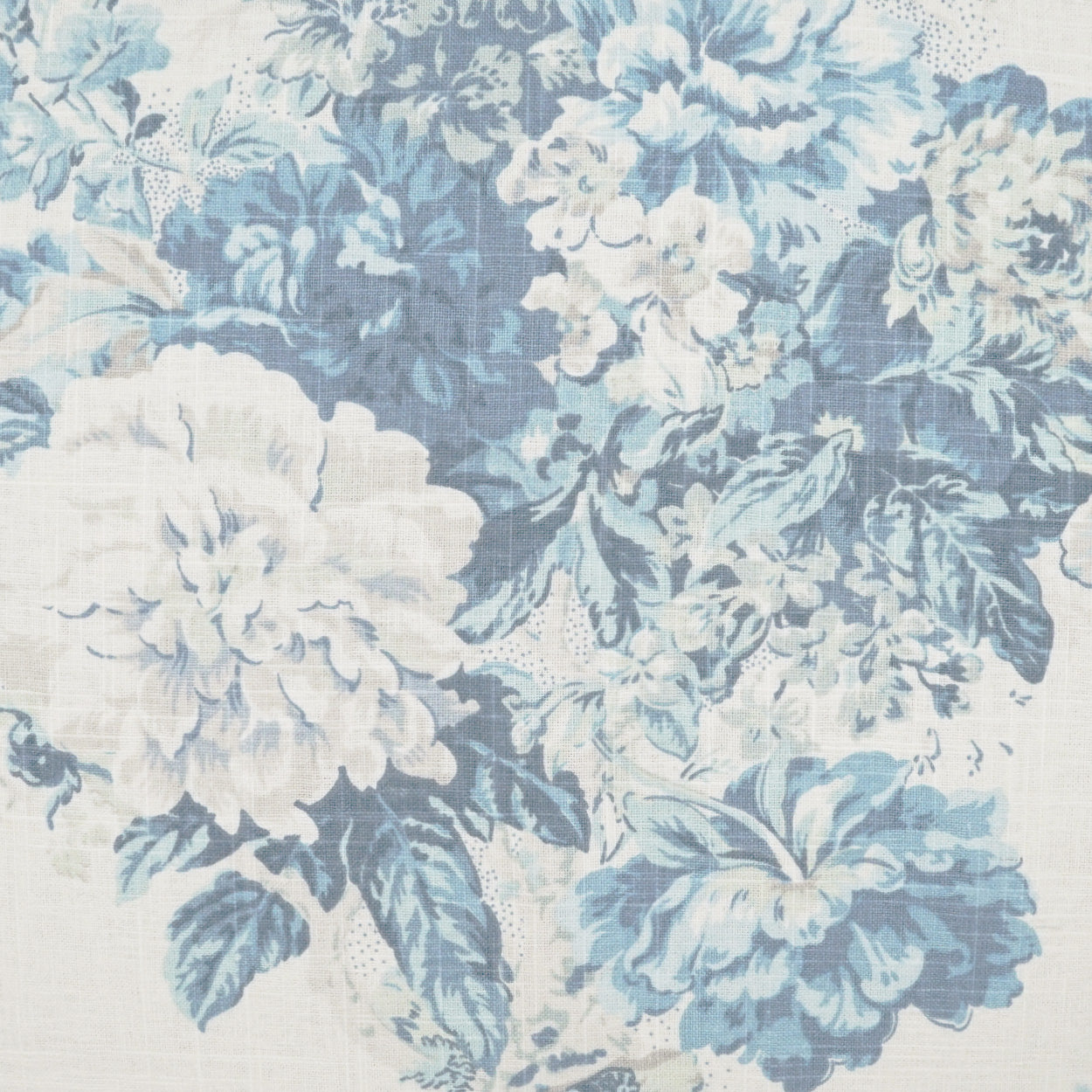 Blue and white floral fabric for upholstery with large blossoms and leaves in a vintage toile-style pattern.