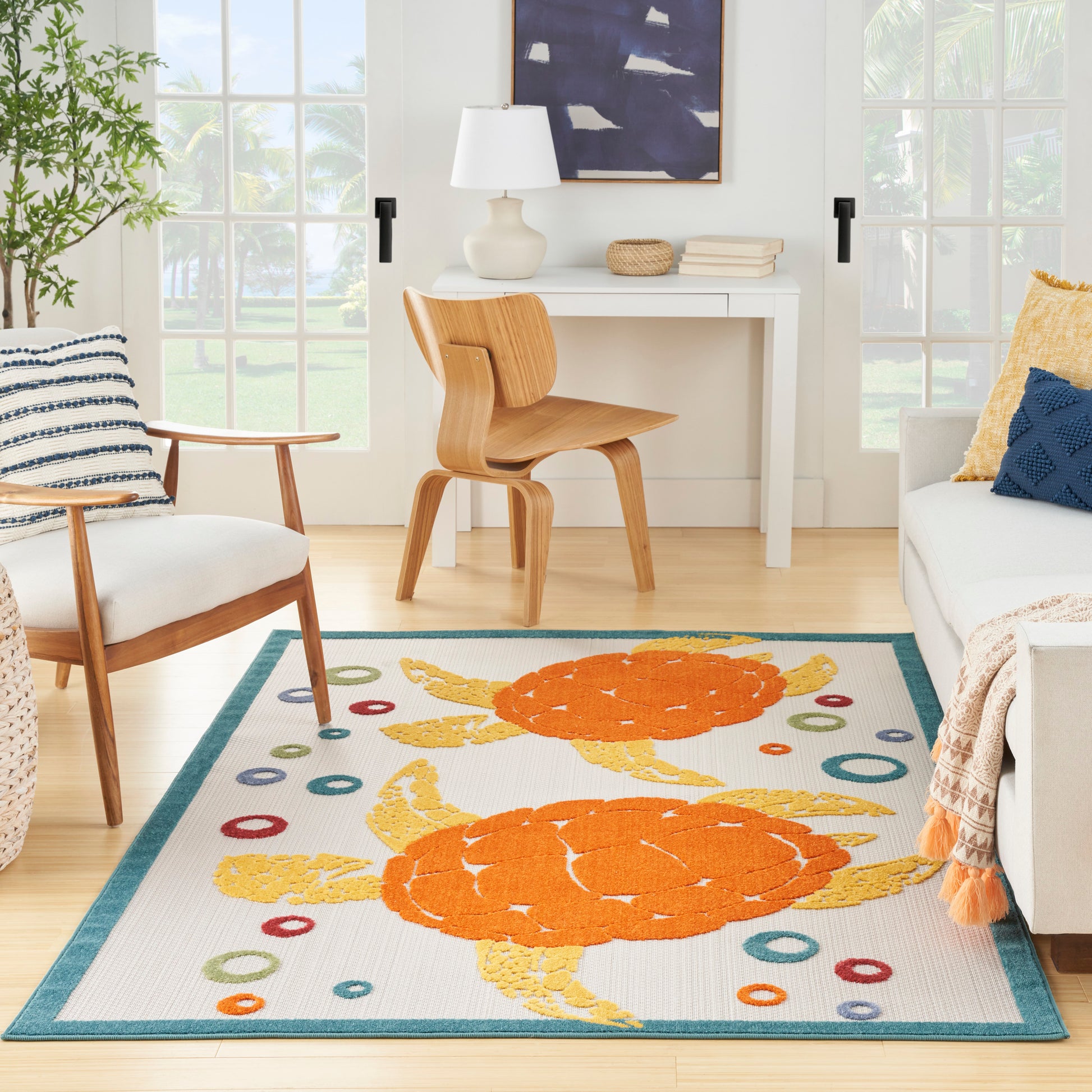 Coastal-style area rug with bright orange crabs, teal border and colorful circles on cream background.