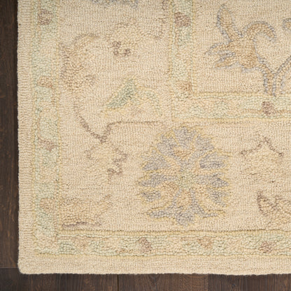 Beige oriental rug corner with pale blue floral medallion and pastel border on dark wood floor