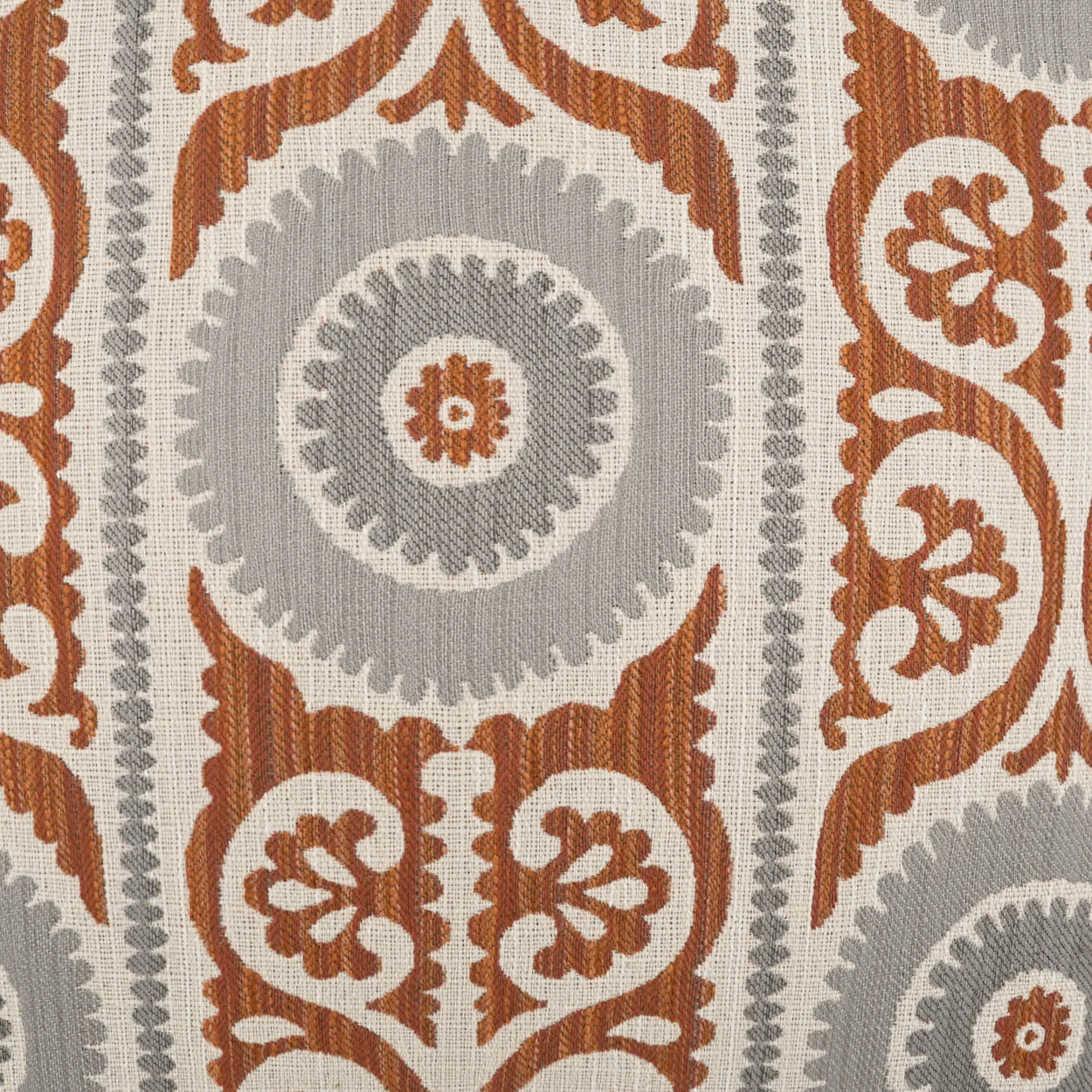 Rust-orange and gray damask pattern with circular rosettes and ornate scrolling motifs on a cream background, shown on a pillow.