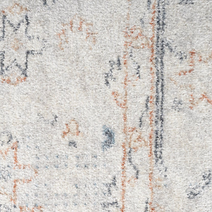 Close-up of a light beige textured rug with abstract blue-gray and rust orange motifs and a dark vertical stripe.