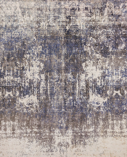Abstract distressed area rug in blue, gray, and beige with a weathered, painterly pattern.