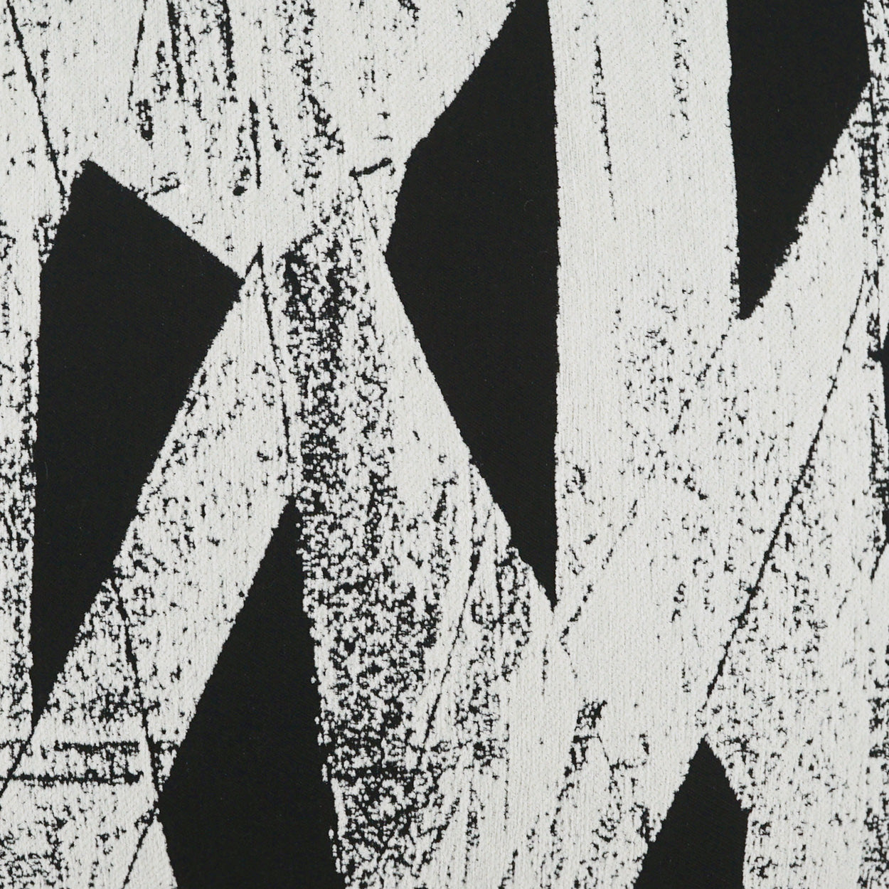 Black and white geometric fabric print with bold diagonal shapes and distressed texture.