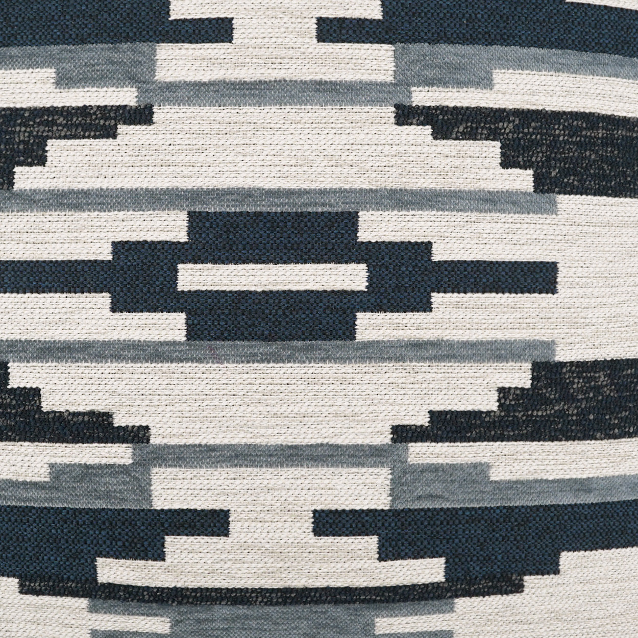 Aztec-inspired geometric pattern on navy, gray, and white woven fabric.