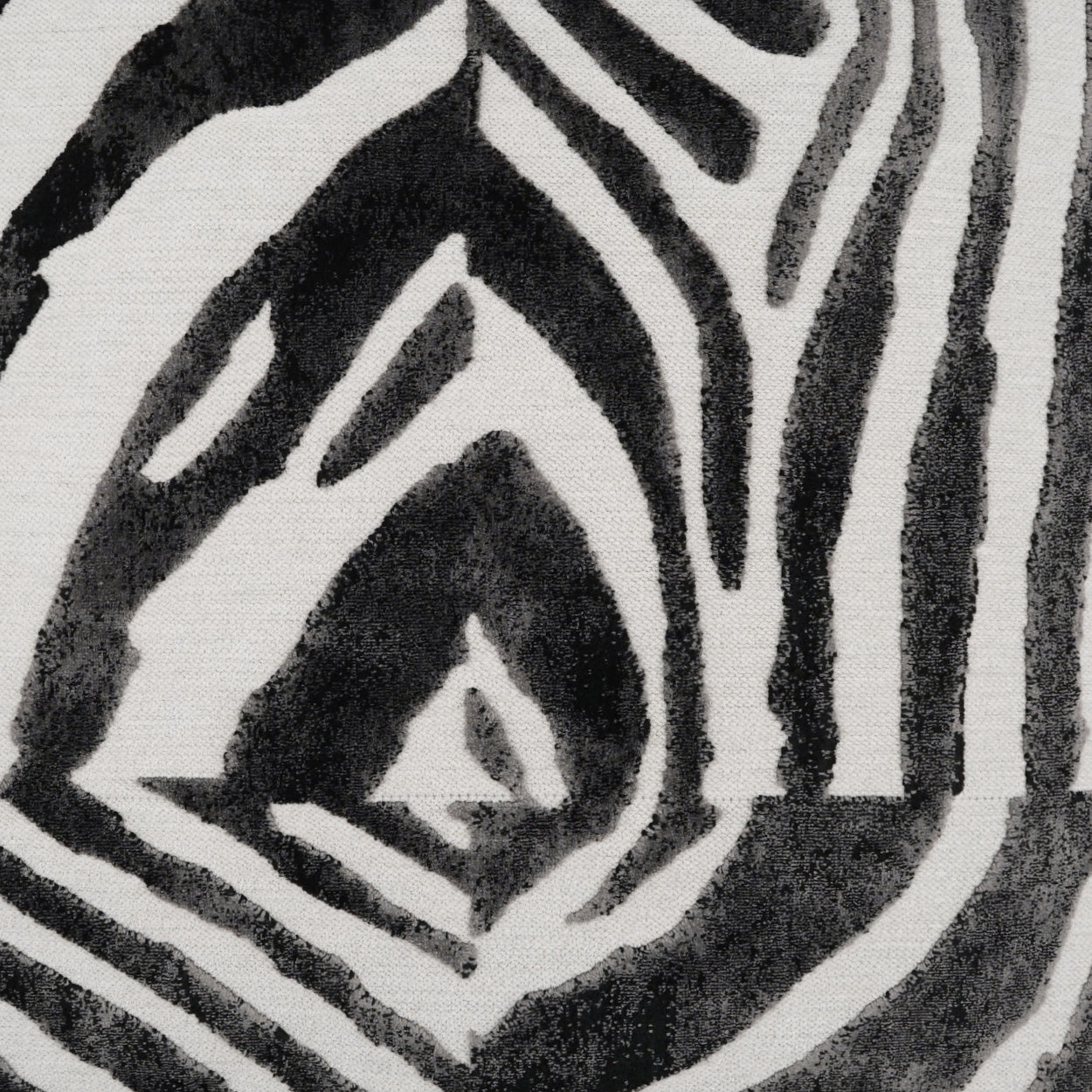 Close-up of black and white zebra-pattern fabric with bold angular stripes and textured weave.