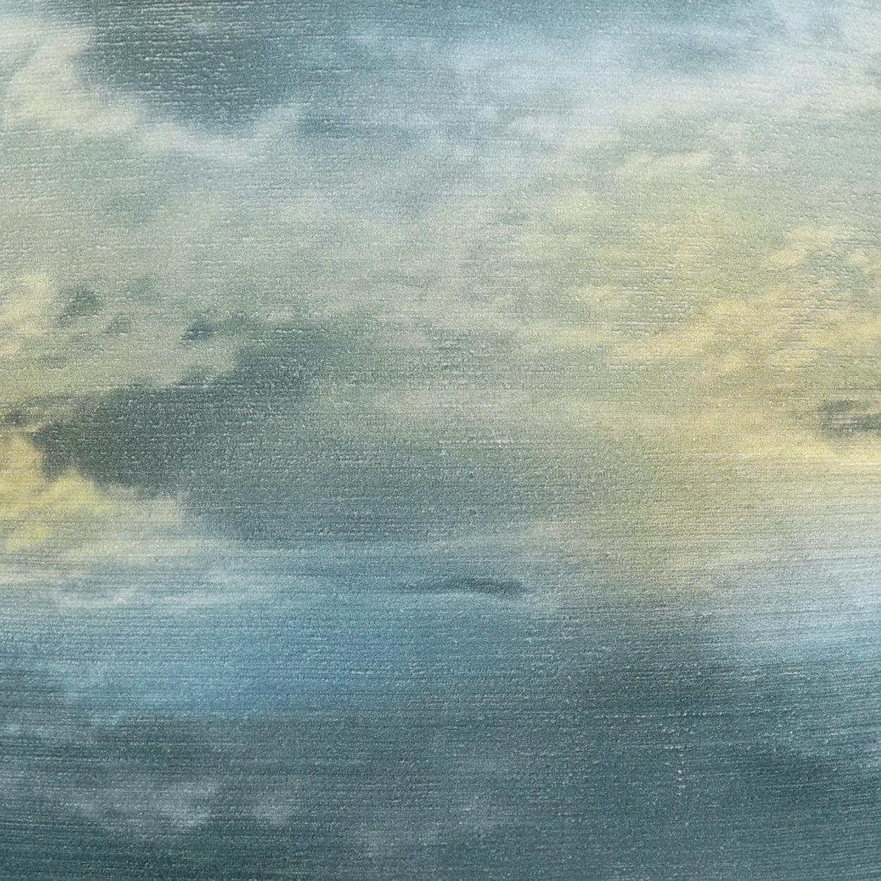 Soft fabric swatch with watercolor gradient in blue, teal, and pale yellow; textured weave.