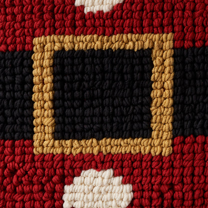 Chunky woven rug close-up with red and black bands and a tan belt-buckle frame around a black center, white tuft accents.