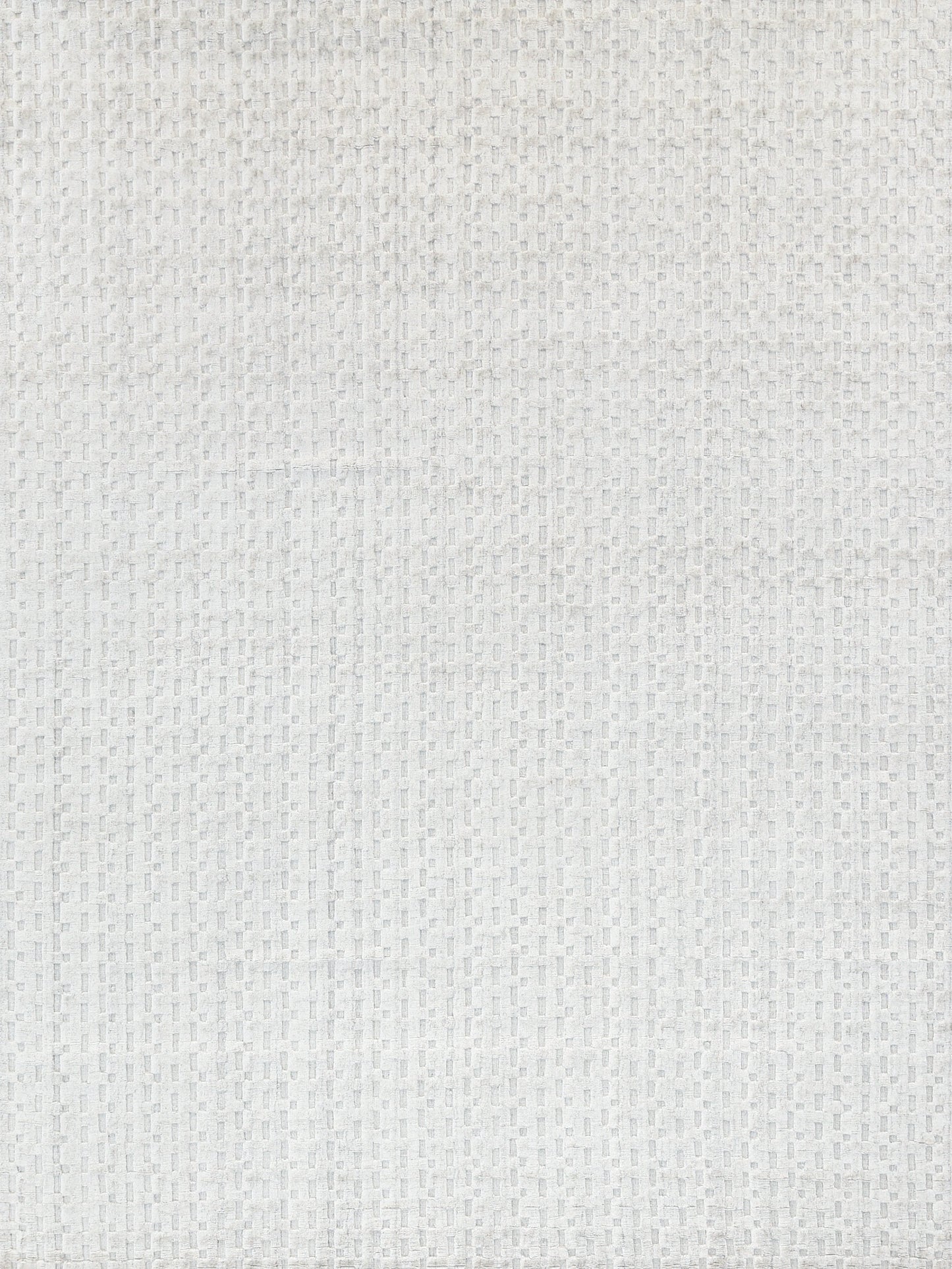 Close-up of a light gray textured rug with a small square grid pattern.