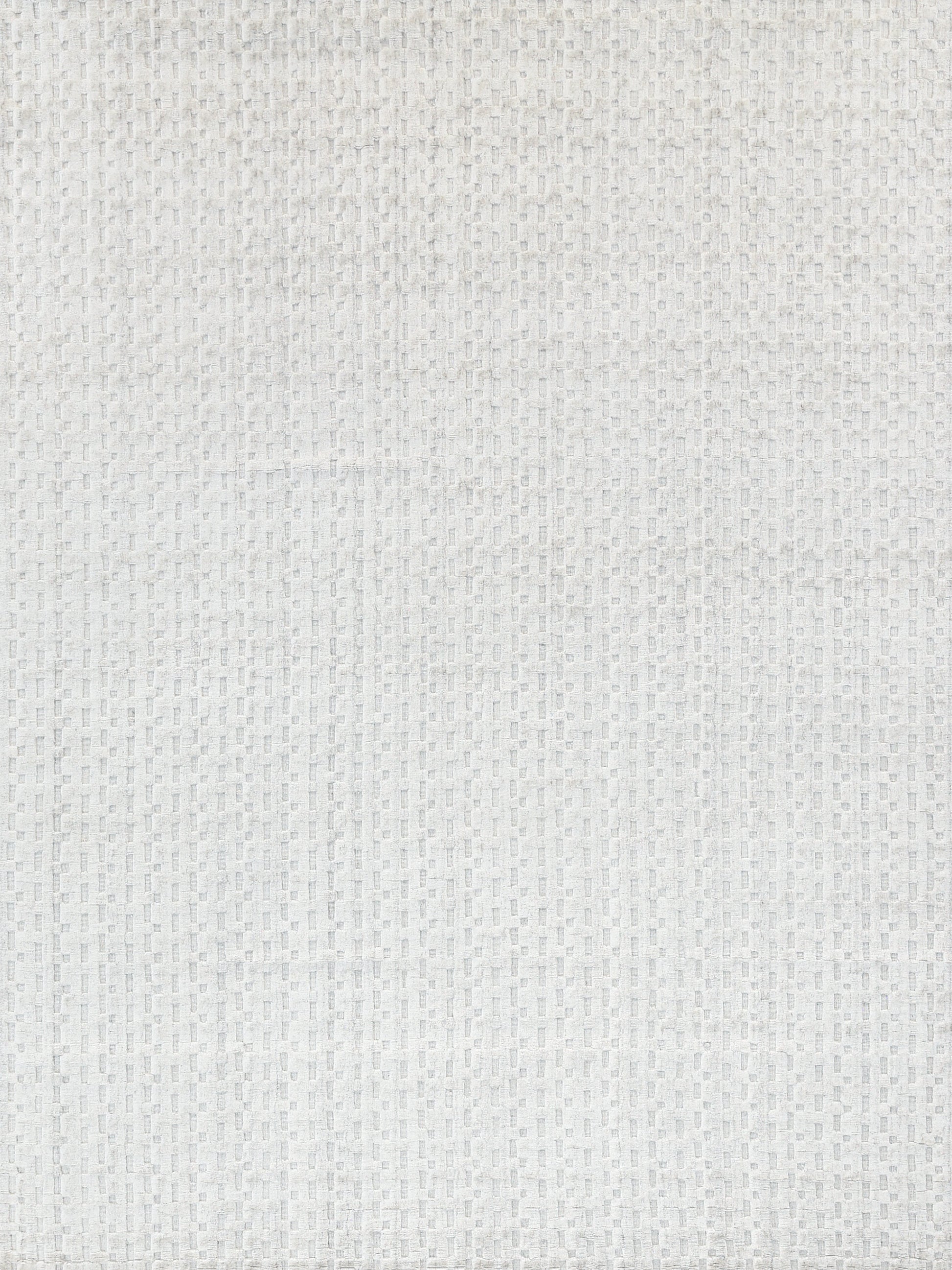 Close-up of a light gray textured rug with a small square grid pattern.