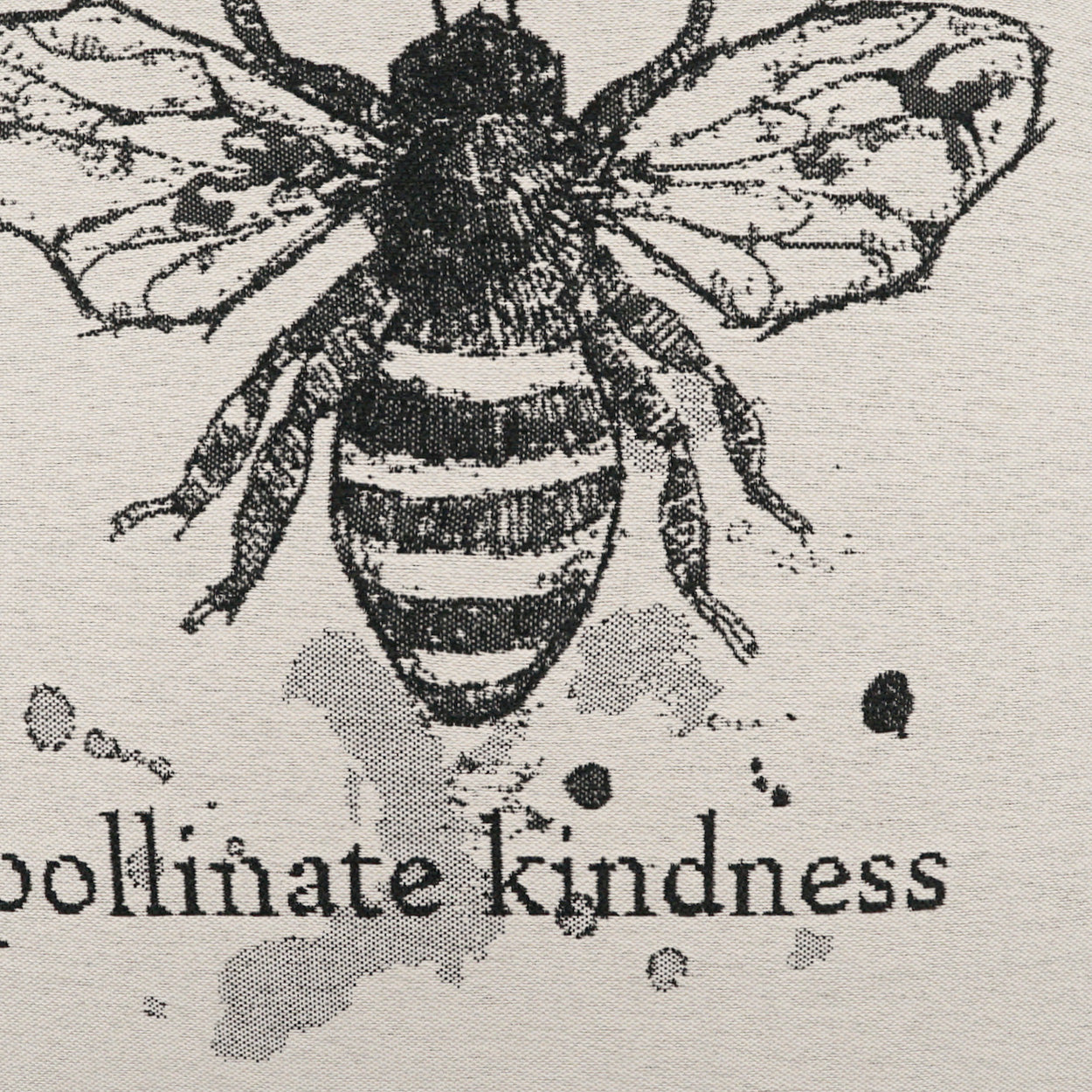 Vintage black bee illustration on beige fabric with ink splatters and the words pollinate kindness.