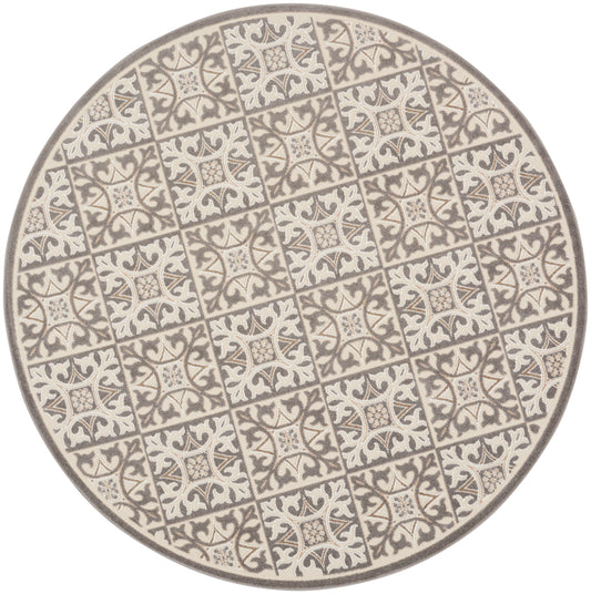 Round ceramic plate with cream and gray tile motif and ornate floral patterns in a repeating grid.