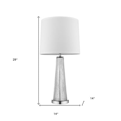 Contemporary table lamp with a textured metallic tapered base, chrome pedestal, and Empire shade.